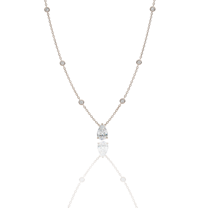 A handcrafted 18kt yellow gold necklace featuring a 1.50 carat G/VS pear-shaped diamond pendant. The delicate gold chain includes 0.40 carats of small, bezel-set diamond accents. Presented by Rebecca’s Diamonds.